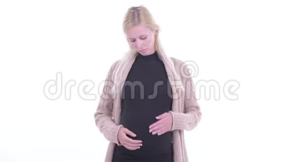 年轻的金发孕妇在竖起大拇指和竖起大拇指之间做出选择视频的预览图