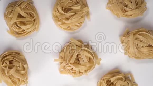 意大利面巢旋在一张白色的桌子上上面是意大利面视频的预览图