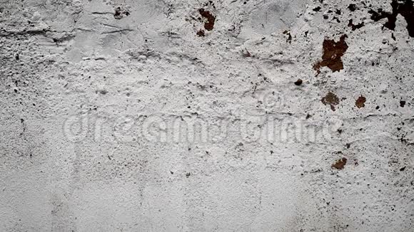 在白色的破旧的混凝土墙上出现了铭文冠状病毒混凝土碎成碎片碎片飞舞视频的预览图
