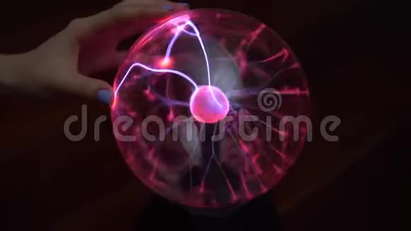 一只雌性的手触摸一个等离子球发出小闪电在黑暗中用电做实验视频的预览图