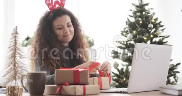 在办公室包圣诞礼物的快乐女人视频的预览图