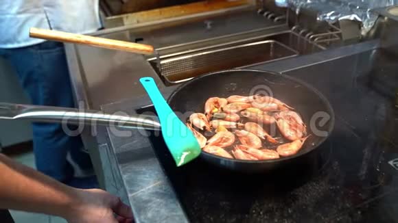 厨师用炉子上的虾调整锅视频的预览图