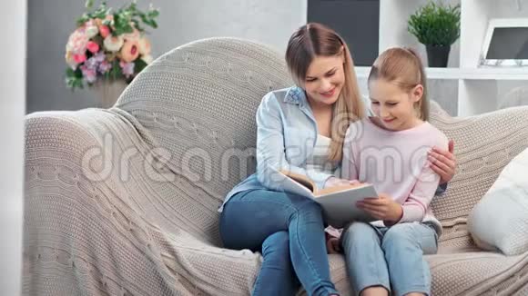 有吸引力的快乐家庭阅读书籍享受周末一起坐在舒适的沙发上视频的预览图