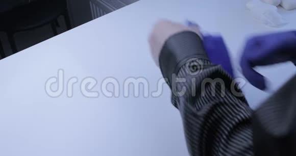 一个男人戴上一次性手套2020年COVID19大流行视频的预览图
