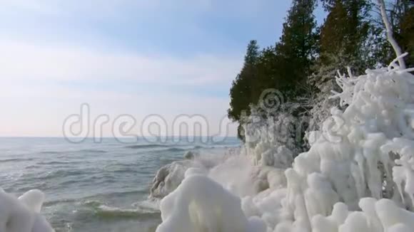 密歇根湖的波浪在威斯康星州的洞穴公园的冰封海岸溅起水花视频的预览图