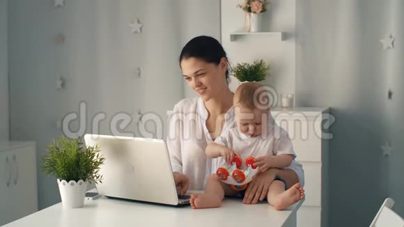 有婴儿和笔记本电脑的女人视频的预览图