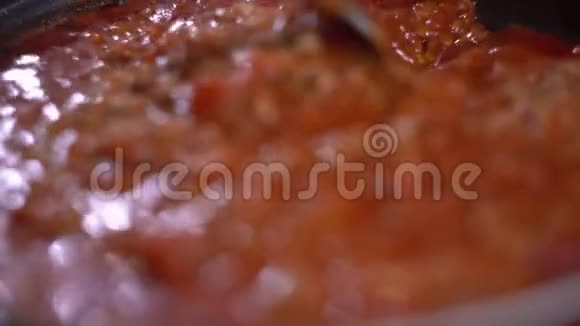 将博洛尼亚面食用黑锅在炉子上煮用红酱把肉打匀视频的预览图