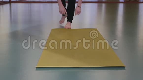 年轻英俊的瑜伽白人他在地板上卷起一块黄色的瑜伽垫视频的预览图