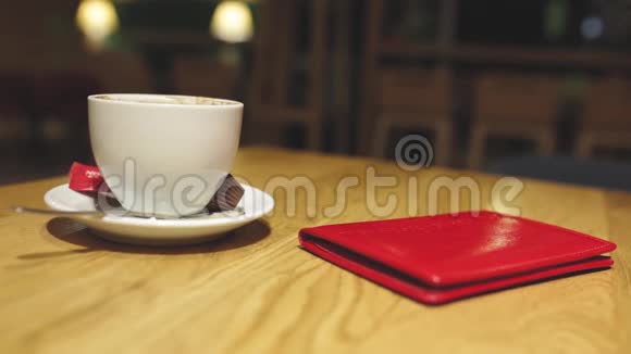 服务员手拿走红色皮革或检查文件夹和空咖啡杯视频的预览图