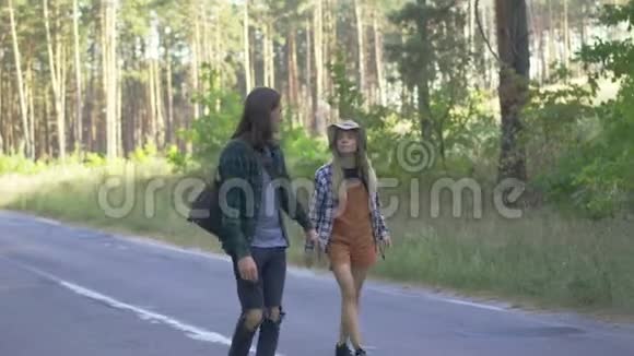 千禧一代游客幸福的一对夫妇穿着格子衬衫沿着马路走着一起在附近旅行视频的预览图