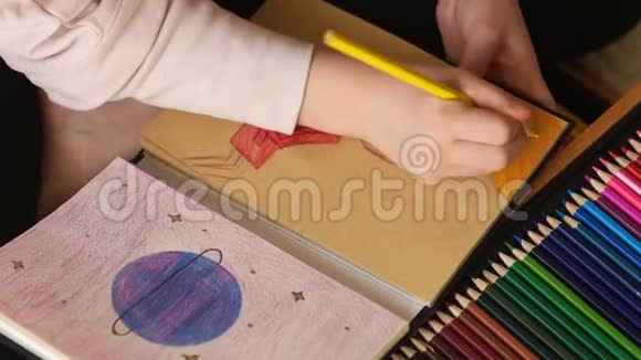 用彩色铅笔在素描盒中绘制儿童手的近距离肖像地球和人类形象视频的预览图