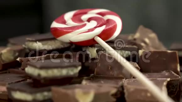 在桌子上旋转的巧克力碎片上用红白相间的糖果或视频的预览图