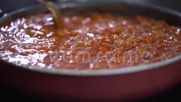 博洛尼亚意大利面是在炉子上用黑锅煮的用红酱把肉打匀视频的预览图