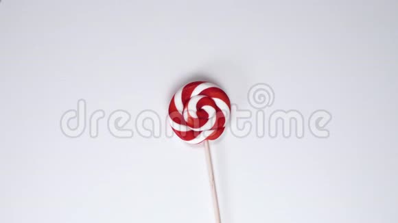 红白糖果或棒棒糖在白色桌子上旋转从上往下看棒糖视频的预览图
