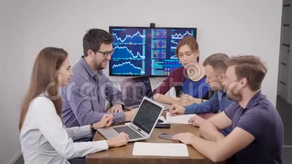 一群年轻的金融专家坐在会议室里墙上挂着时间表视频的预览图