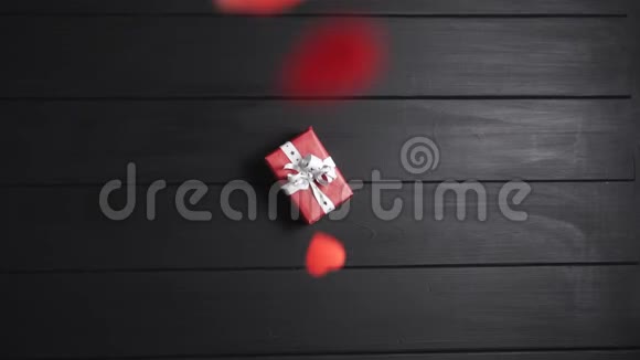 许多红心落在桌子上桌子上放着一个带礼物的盒子视频的预览图