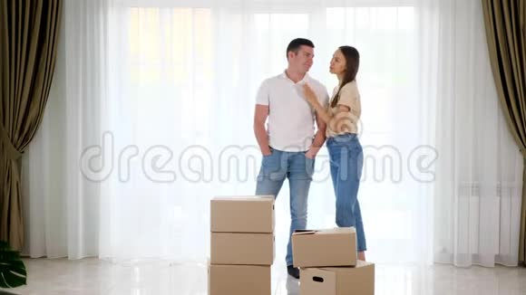 一对穿牛仔裤的夫妇在新房子里布置家具视频的预览图