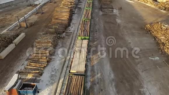锯木厂伐木火车的鸟瞰图堆放着木头和树干在美国境内的火车视频的预览图