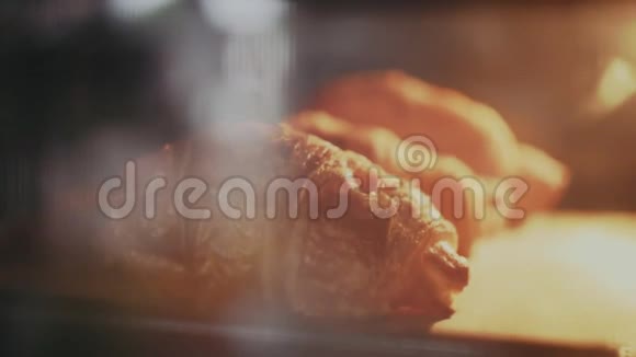 烤箱里的托盘上放着美味新鲜的羊角面包视频的预览图