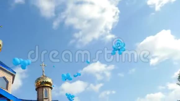 蓝天白云背景下的金色教堂圆顶许多蓝色气球在天空中飞翔正统东正教视频的预览图