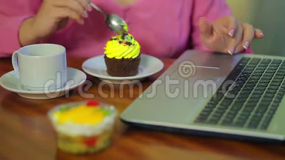女性的手在电脑上工作吃蛋糕喝咖啡视频的预览图