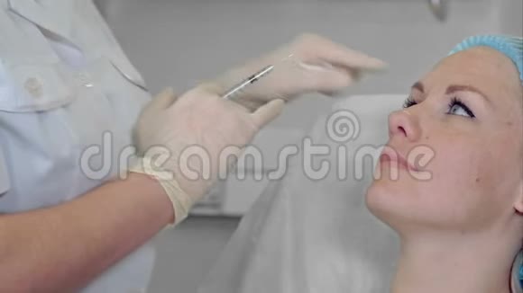 专业美容师为她的女性客户做美容注射振兴女性客户抗衰老肉毒素美容填充物视频的预览图