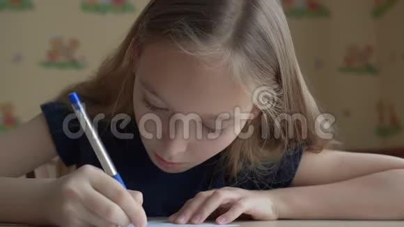 可爱的微笑女孩在桌子上用笔在纸上说话和写作视频的预览图