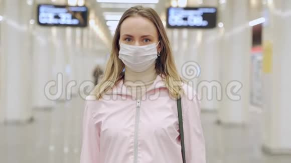 戴防护无菌医用面罩的妇女在地铁站看摄像机病毒大流行冠状病毒概念视频的预览图