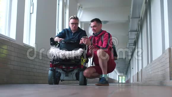 长走廊中与残疾人交谈的男子视频的预览图