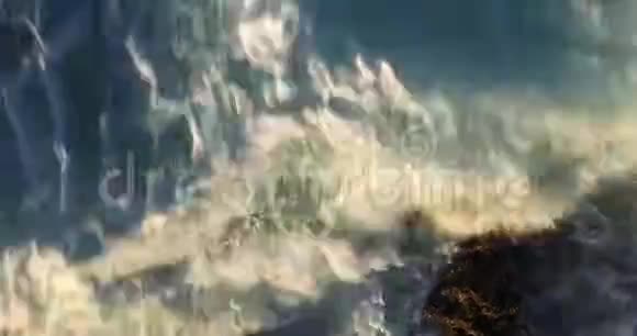 从上到下的高空俯瞰海浪溅落在海岸岩石上视频的预览图