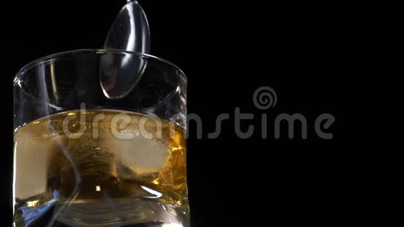 酒保在一个玻璃中搅拌冰块木条柜台上有吧勺有选择的焦点慢动作视频的预览图