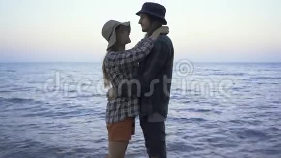 穿着格子衬衫和帽子拥抱在海滨的海普斯特白种人游客夫妇视频的预览图