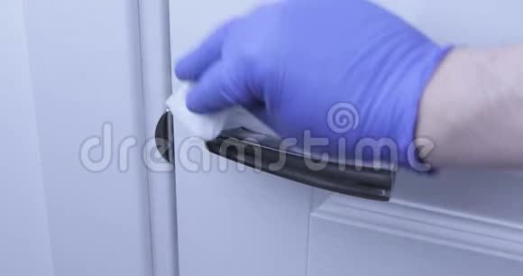 男人用消毒剂擦拭门把手COVID192020年大流行病视频的预览图