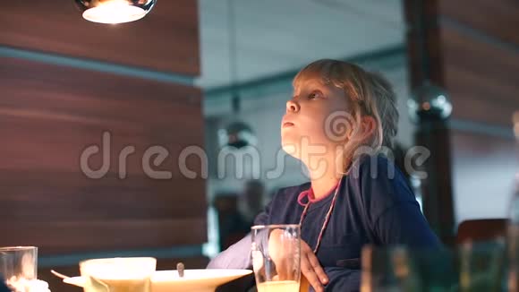 一个女孩坐在学校餐厅的桌子旁视频的预览图