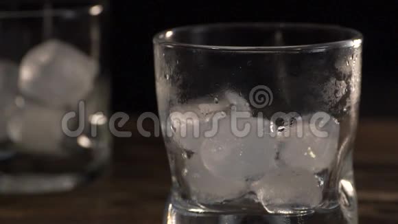 金色麦芽威士忌倒入装有冰块的玻璃杯中视频的预览图