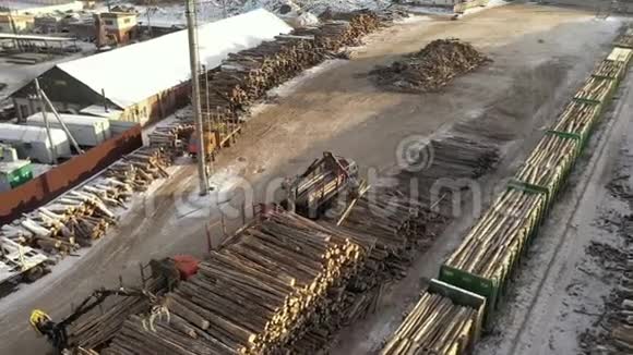 机械夹持器装载木材到卡车上运输的鸟瞰图森林砍伐概念一列伐木火车视频的预览图