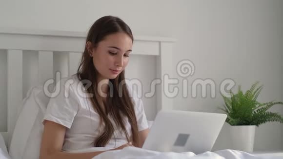 女孩在笔记本电脑上上网聊天躺在床上视频的预览图
