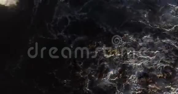 从上到下的高空俯瞰海浪溅落在海岸岩石上视频的预览图
