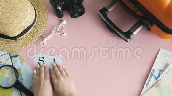 顶部的双手躺在粉红色的书桌上上面写着新加坡语视频的预览图