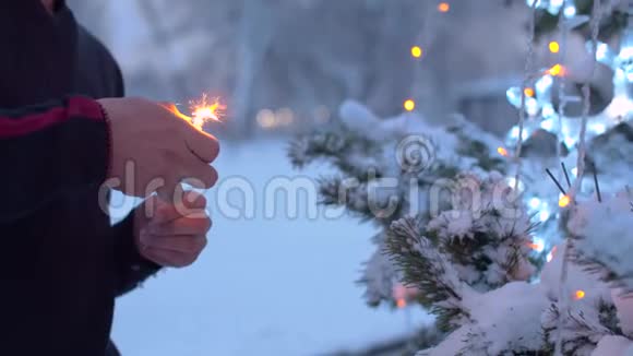 男性手在圣诞树上点燃火花视频的预览图