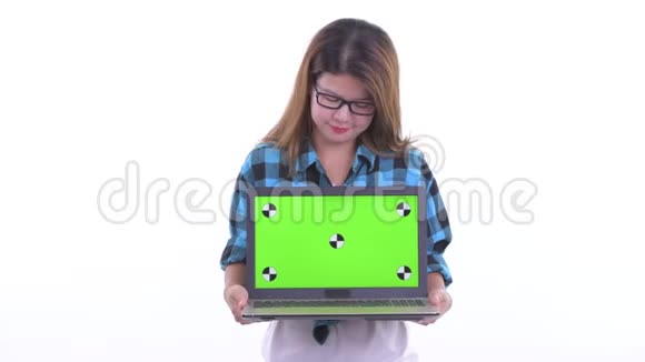 快乐的年轻亚洲潮女一边说一边展示笔记本电脑视频的预览图