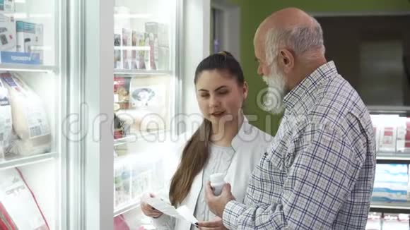 年轻的白种人药剂师帮助顾客在药房选择药物高级胡子顾问视频的预览图
