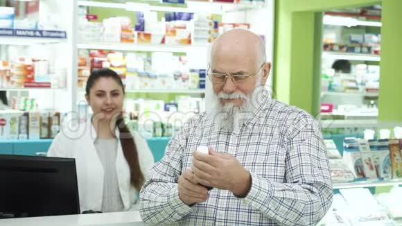 戴眼镜的大胡子男子在药房检查药物微笑着对着镜头药剂师在等视频的预览图