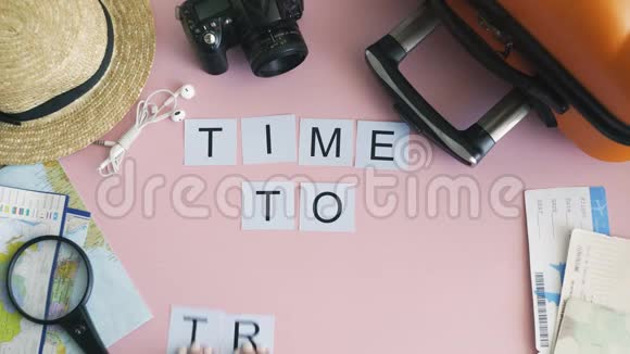 顶部的双手躺在粉红色的桌子上写着旅游的时间视频的预览图