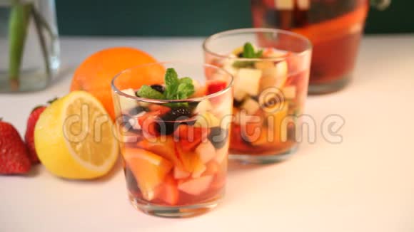 红酒新鲜桑格里亚酒或带水果和浆果的酒女人的手把草莓放在附近视频的预览图