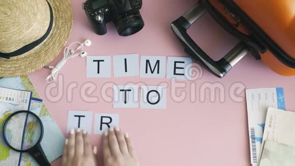 顶部的双手躺在粉红色的桌子上写着旅游的时间视频的预览图