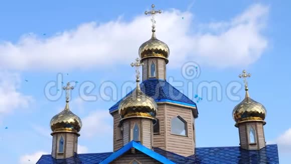 蓝天白云背景下的金色教堂圆顶许多蓝色气球在天空中飞翔东正教视频的预览图