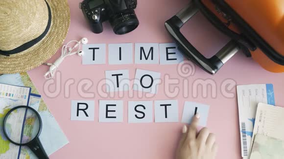 顶部的双手躺在粉红色的桌子上上面写着时间视频的预览图