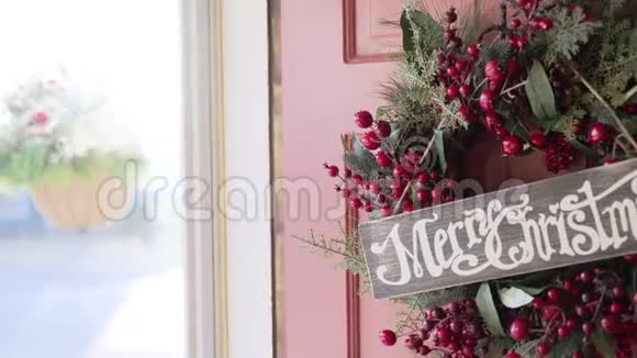 圣诞早晨圣诞快乐门上挂着圣诞标语和花环视频的预览图