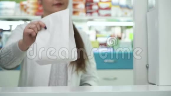 微笑的药剂师把白色纸袋和药物给男性顾客药房采购流程视频的预览图